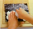 Adding the sushi rice to the nori